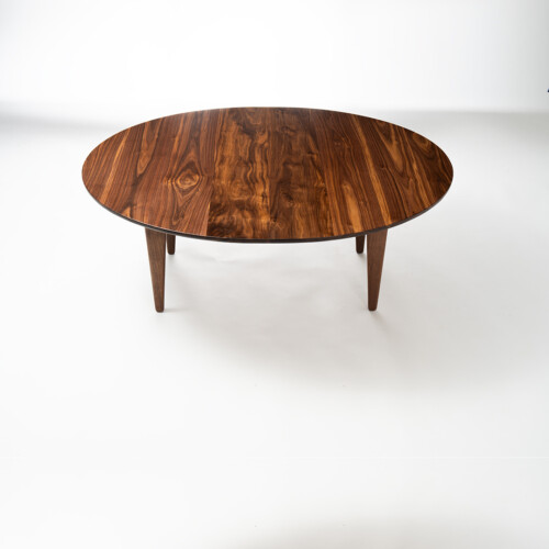 Convertible walnut table lowered to coffee height, angled view