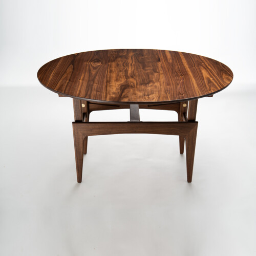 Convertible walnut table at dining height, angled view showing figured walnut top